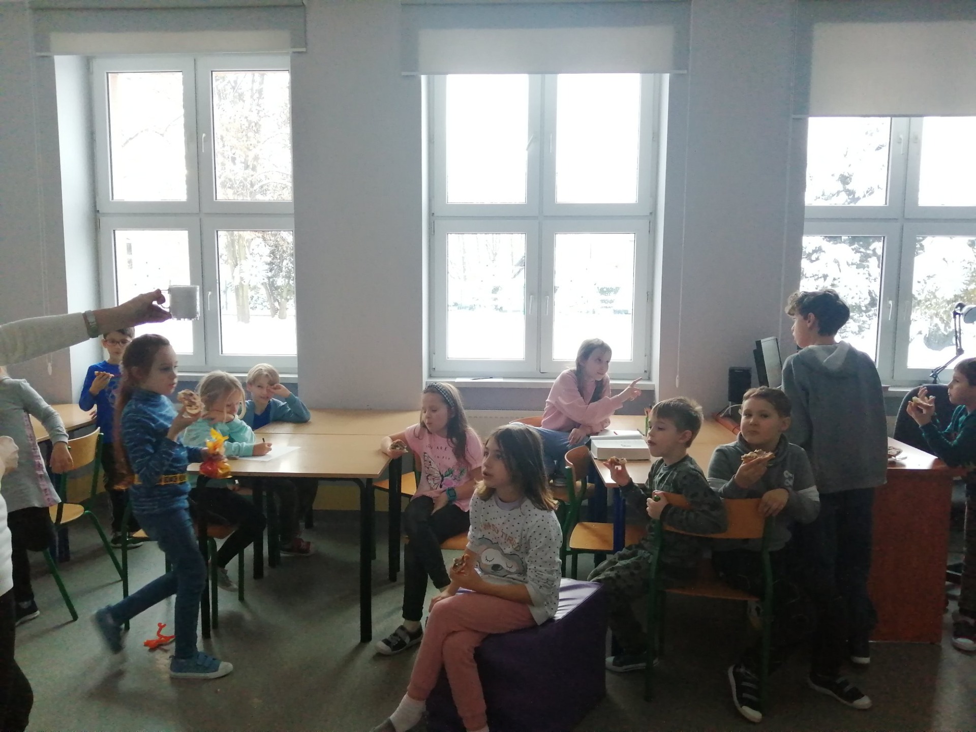 Dzieci na świetlicy siedzą przy stolikach i obserwują eksperyment