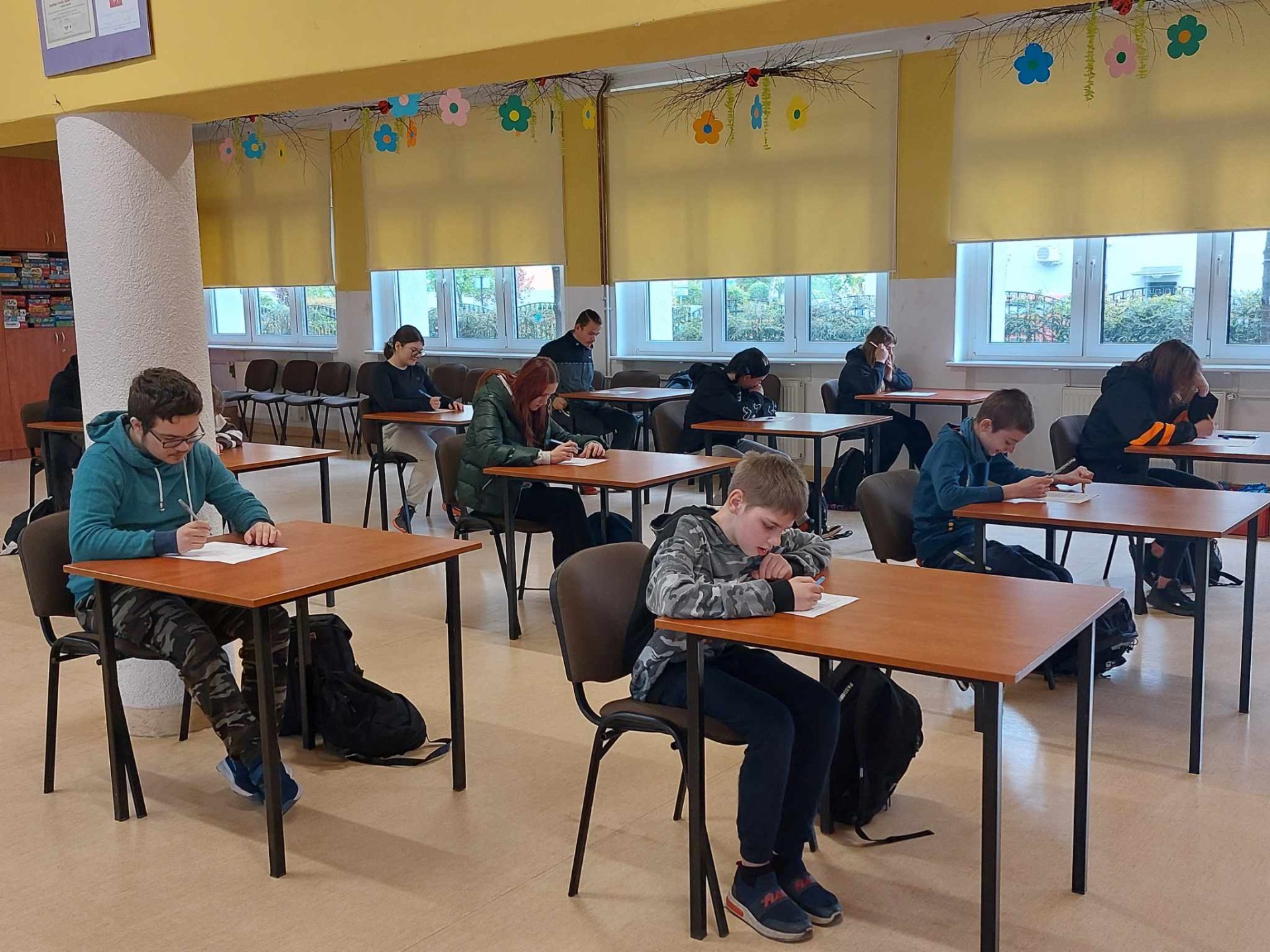 Grupa uczniów pisze test na świetlicy szkolnej