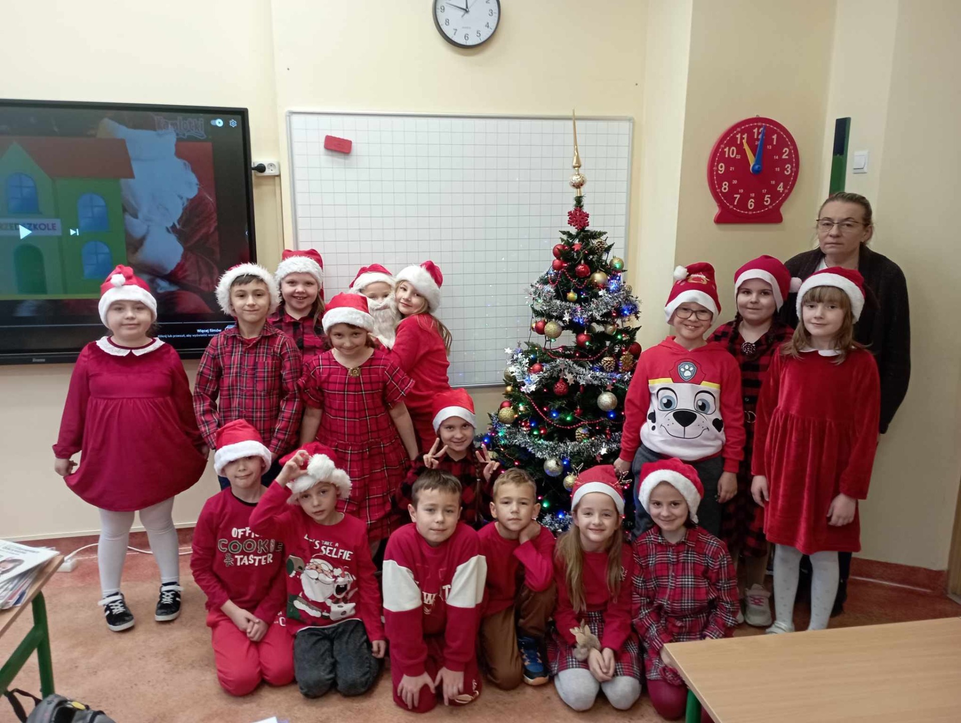 Uczniowie Szkoły Podstawowej Nr 2 im. Mikołaja Kopernika w Olecku w kolorach czerwonych Świętego Mikołaja