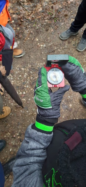2. dziecko w zielonych rękawiczkach trzyma w dłoniach kompas.
