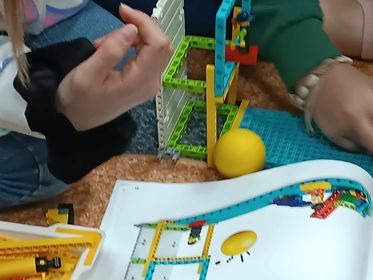 Uczniowie budują budowle z zestawów klocków LEGO