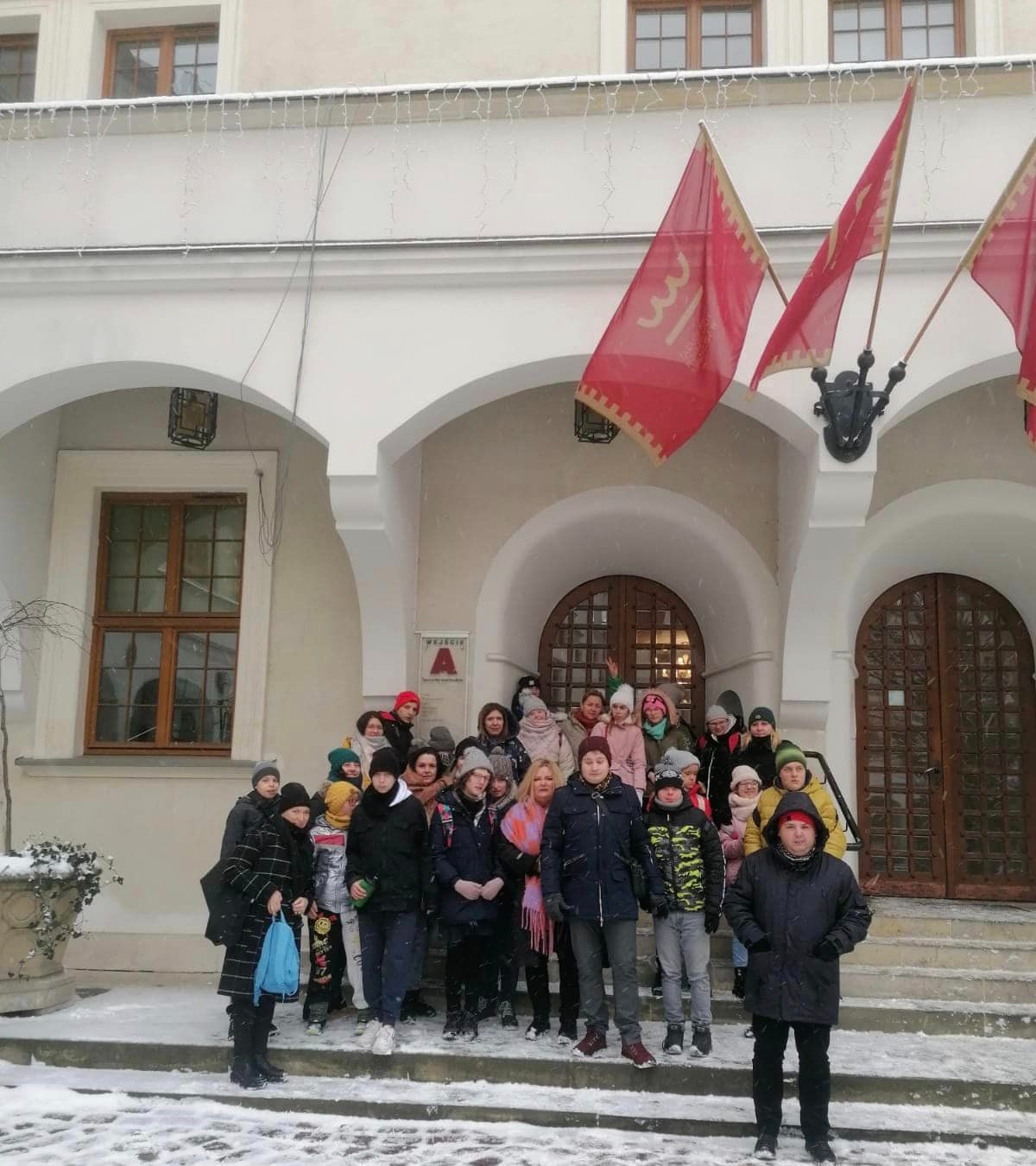 Grupa uczniów i nauczycieli przed budynkiem Zamku Książąt Pomorskich w Szczecinie.