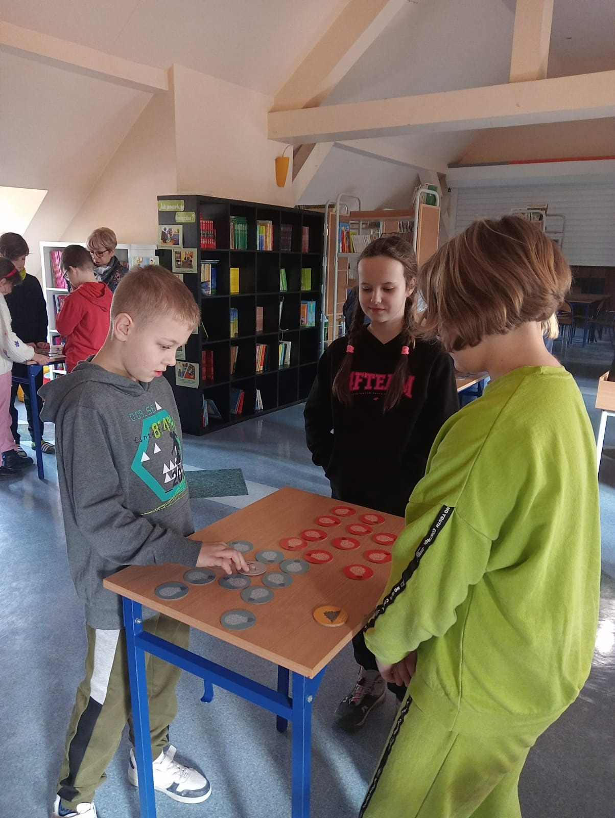 uczniowie grają w grę w bibliotece szkolnej