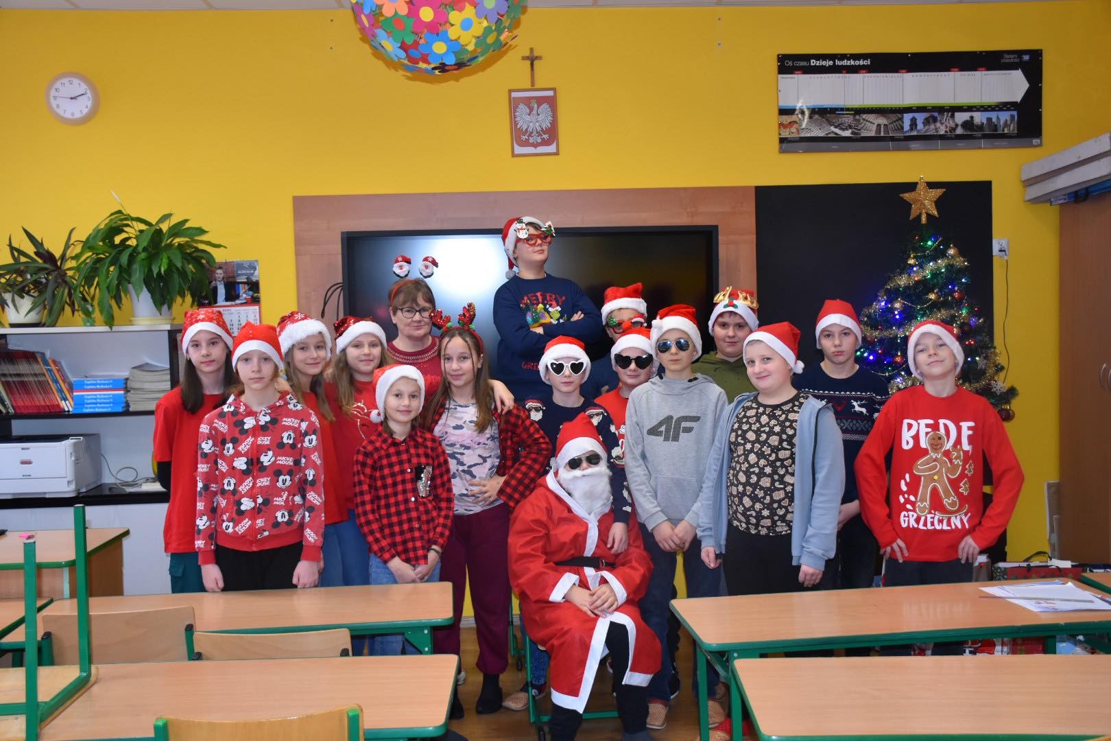 Grupa uczniów wraz z Mikołajem w sali lekcyjnej