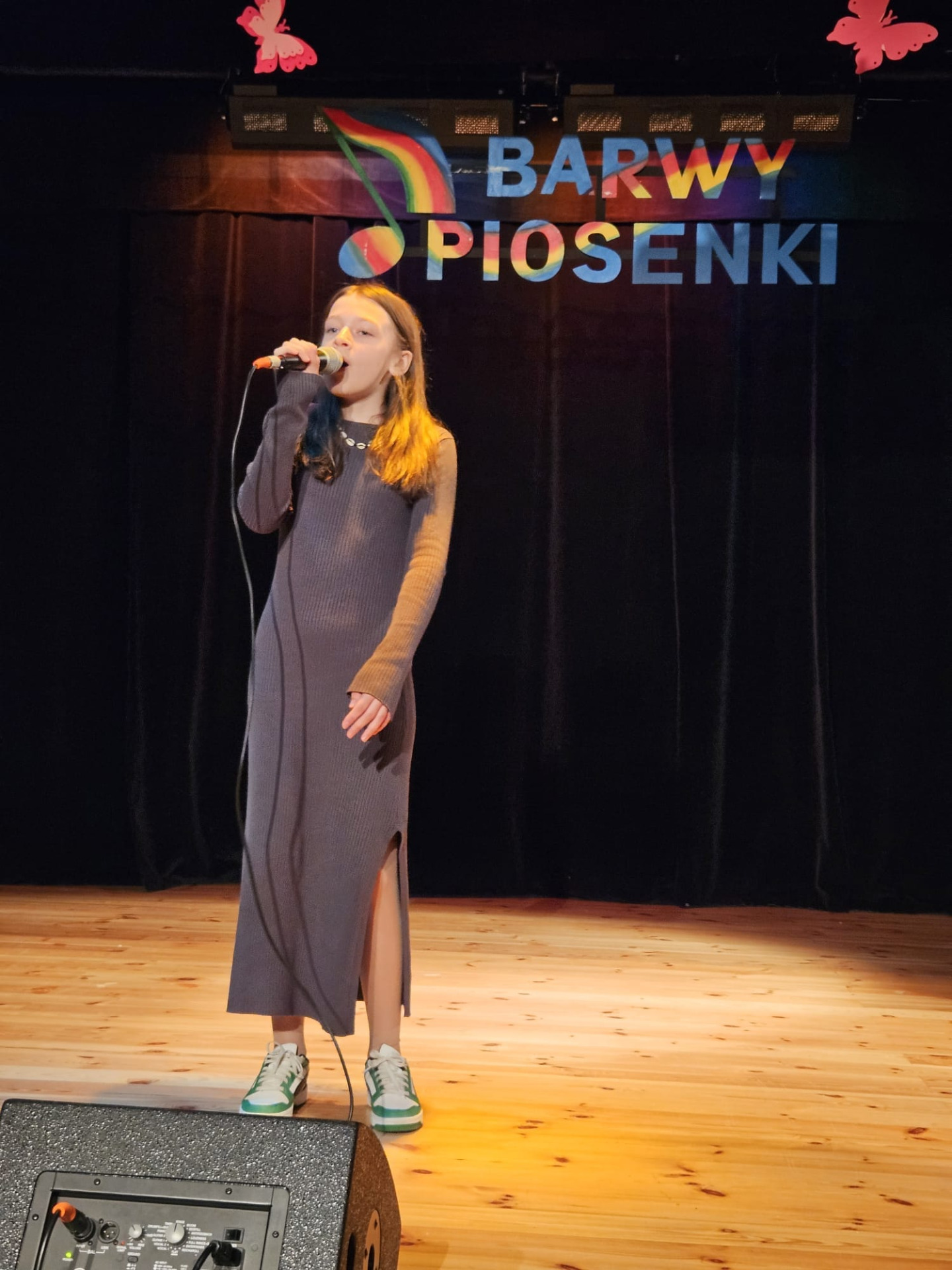 Zuzia na scenie teatru podczas śpiewania piosenki